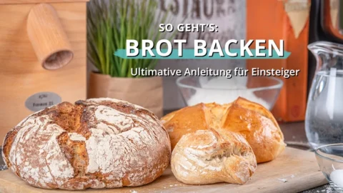 Verschiedene frisch gebackene Brote auf einem Holzbrett in einer Küchenumgebung