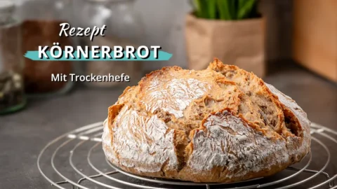 Rundes frisch gebackenes Körnerbrot mit knuspriger Kruste auf einem Abkühlgitter